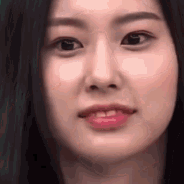 a close up of a woman 's face with long black hair .