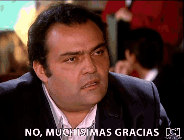 a man in a suit says no muchisimas gracias on a screen