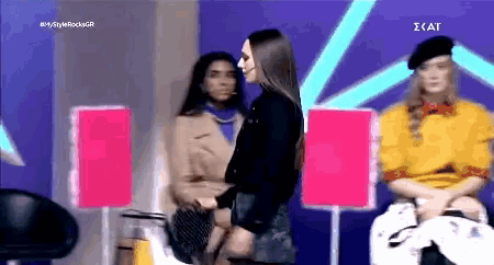 two women are standing next to each other in front of a sign that says ' ikat ' on it