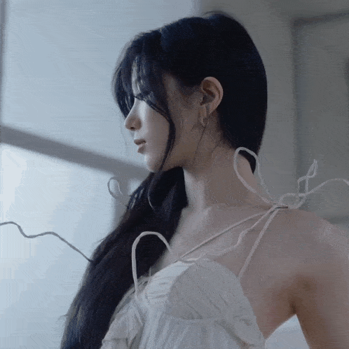 a woman in a white dress with a ribbon around her neck