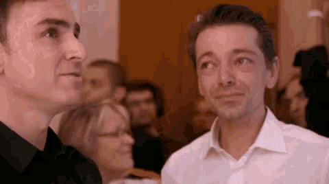 two men are standing next to each other in a crowd .