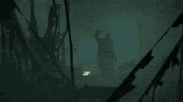 a person is holding a wand with a green light coming out of it in a dark room .