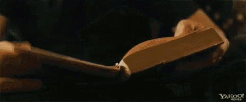 a person is reading a book with yahoo movies written on the bottom of the screen