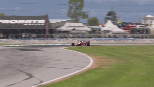 a race car is going around a curve in front of a building that says prorata