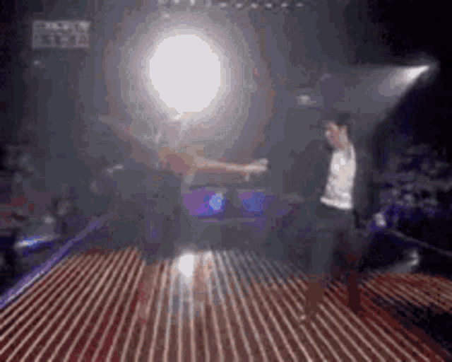 a man and woman are dancing on a stage in a dark room .