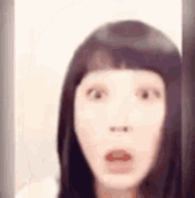 a woman with long hair is making a surprised face .