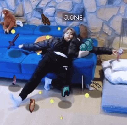 a person laying on a blue couch with a sign that says j.one