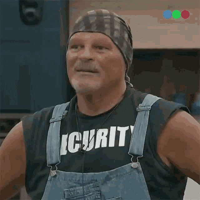 a man wearing overalls has a shirt that says security on it
