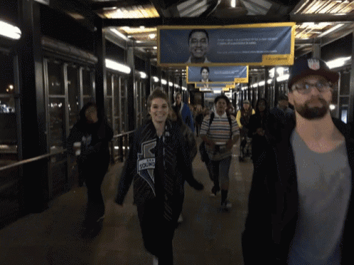 a group of people are walking across a bridge with a sign that says dhl