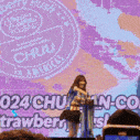 a woman stands at a podium in front of a sign that says chuu in americas