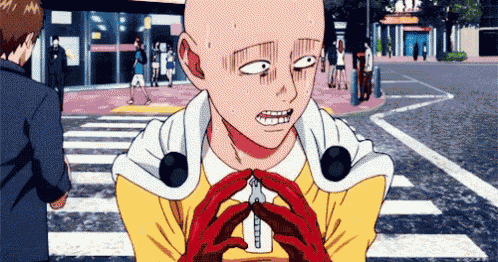 a bald man in a yellow jacket and red gloves is standing on a street .