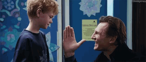 a man and a boy are giving each other a high five in front of a sign that says january