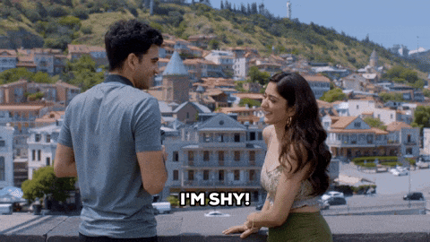 a man and a woman are standing next to each other and the woman says i 'm shy