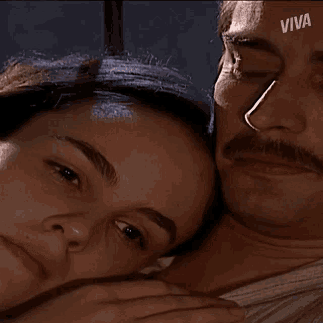 a man and a woman are laying next to each other and the word viva is on the bottom right