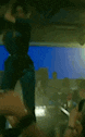 a blurry picture of a person standing in a dark room with a blue background .
