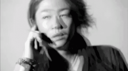 a woman is talking on a cell phone in a blurry photo .