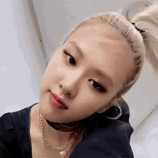a close up of a woman 's face wearing a choker and a ponytail