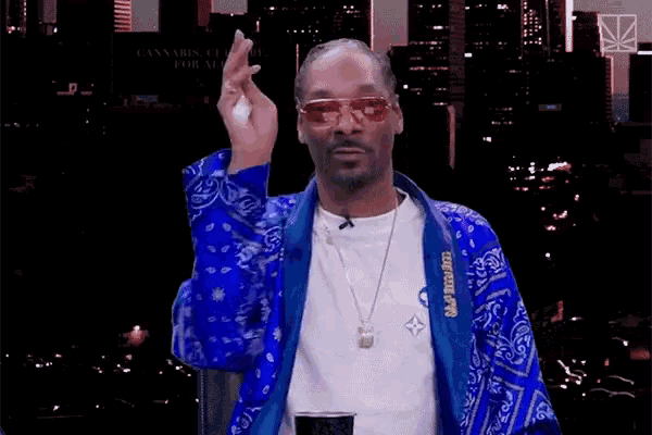 snoop dogg is wearing a blue jacket and sunglasses while holding a can of beer
