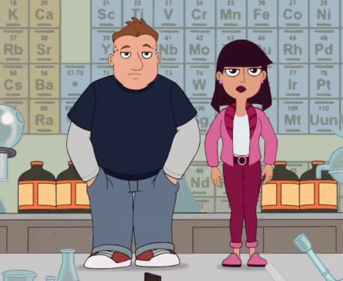 a man and a woman stand in front of a periodic table
