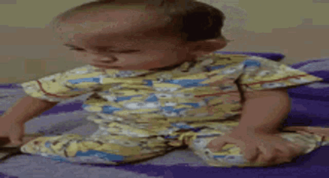 a baby is sitting on a purple rug and smiling