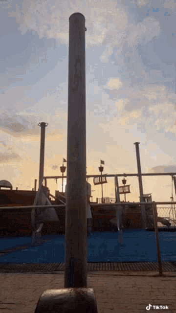 a person is doing a trick on a pole in front of a playground with a tiktok watermark