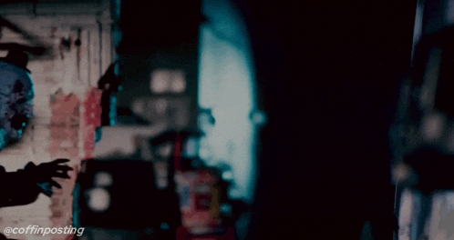 a creepy clown is standing in a dark room with the hashtag @coffinposting below him