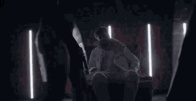 a man is standing in a dark room with smoke coming out of the ceiling .