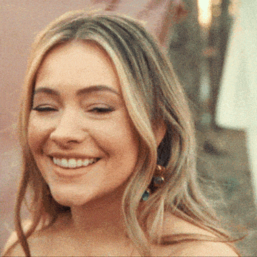 a close up of a woman 's face with her eyes closed smiling