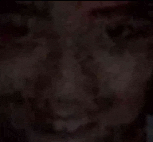 a close up of a man 's face in a dark room .