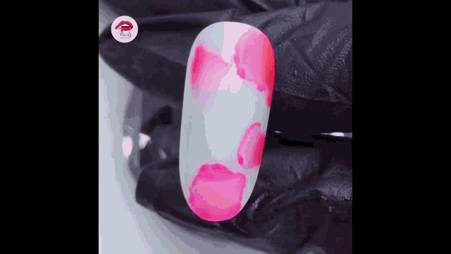 a close up of a person 's nail with pink spots on it