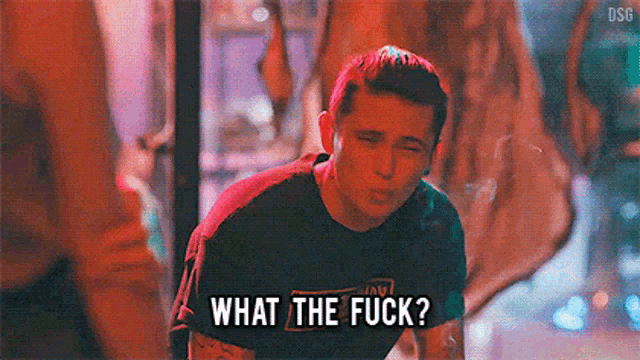 a man in a black shirt is smoking a cigarette and says `` what the fuck '' .