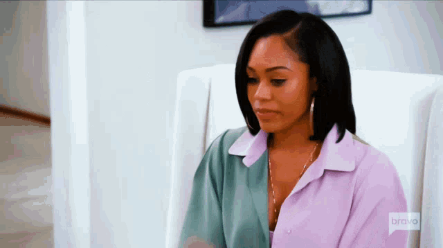 a woman sits in a chair with bravo written on the sleeve of her shirt