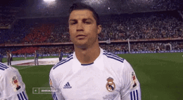 a soccer player wearing an adidas shirt stands on a field