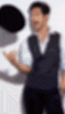 a blurry picture of a man wearing a black vest
