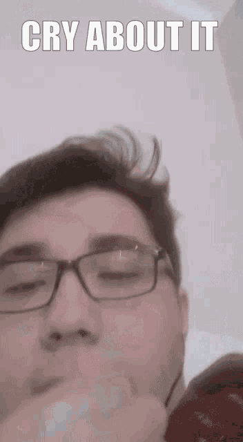 a close up of a man wearing glasses with a caption that says cry about it .