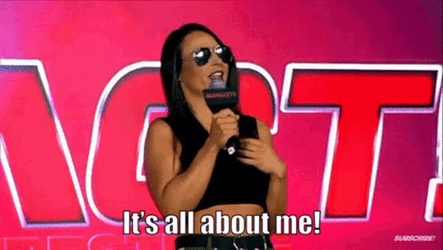 a woman wearing sunglasses is holding a microphone and says `` it 's all about me ! ''