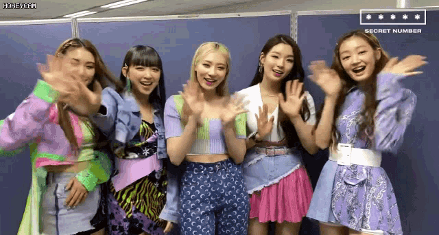 a group of girls standing next to each other with a sign that says secret number above them