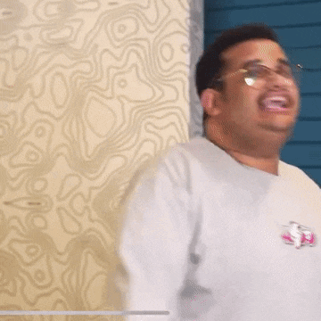 a man wearing glasses and a gray shirt with a sticker that says ' ss ' on it
