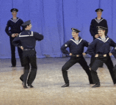 a group of men in sailor uniforms are dancing on stage