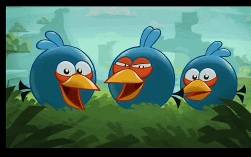 three blue birds with orange beaks are standing in the grass