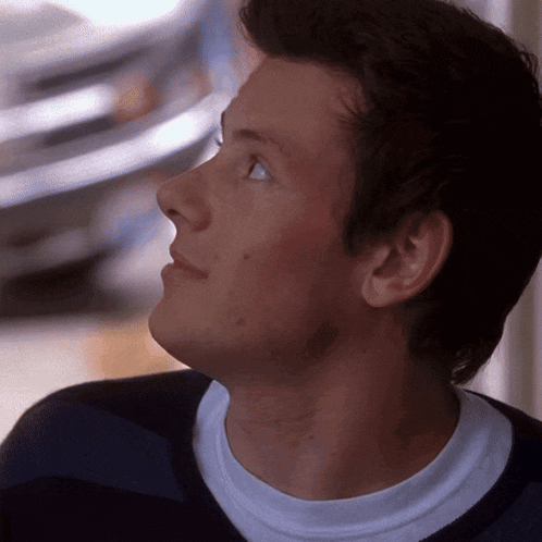a close up of a man 's face with a white shirt on