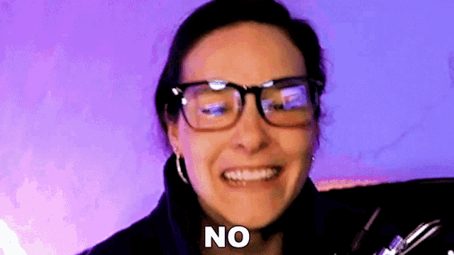a woman wearing glasses is making a funny face and saying `` no '' .