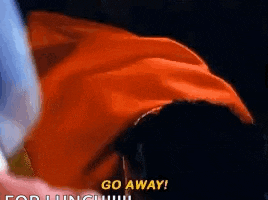 a close up of a person holding a red cape with the words `` go away '' written on the bottom .