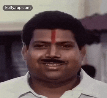 a man with a mustache is smiling with a red stripe on his forehead .