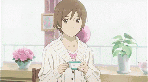 a girl in a white sweater is drinking from a cup .