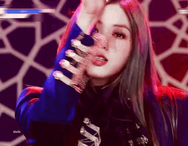 a woman is wearing a blue jacket and gloves with rhinestones on them .