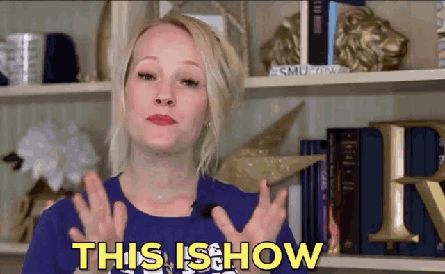 a woman says " this is how " while standing in front of a bookshelf