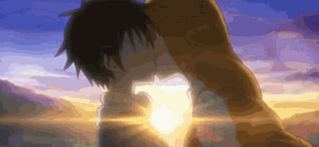 a couple kissing in front of a sunset