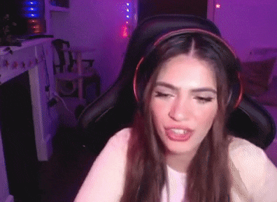 a young woman wearing headphones is sitting in a gaming chair .