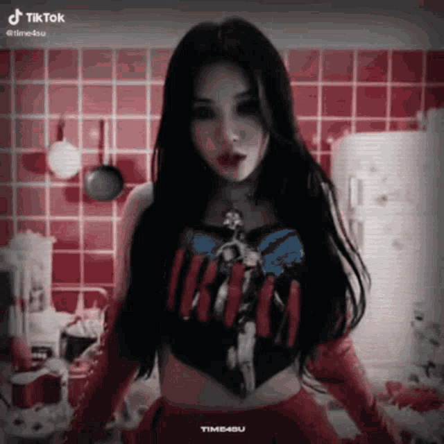a woman wearing a nirvana shirt and red gloves is standing in front of a red tiled wall .